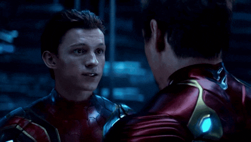 two men in superhero costumes are looking at each other