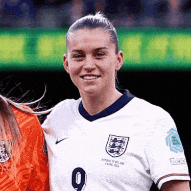 a woman in a republic of england jersey smiles for the camera