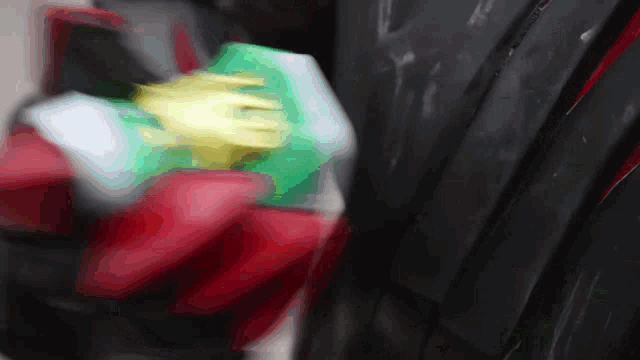 a blurred image of a red yellow and green object on a black surface