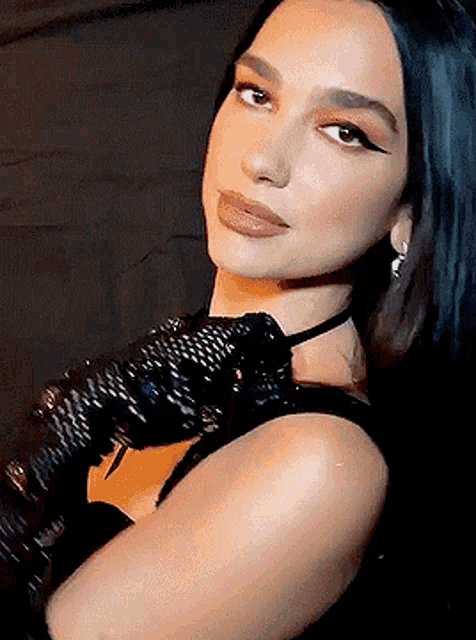a close up of a woman wearing a choker and gloves .