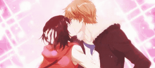 a man and a woman are kissing each other in front of a pink background .