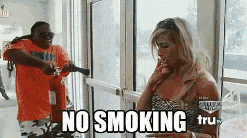a man is pointing a gun at a woman who is smoking a cigarette and the words no smoking are above her .