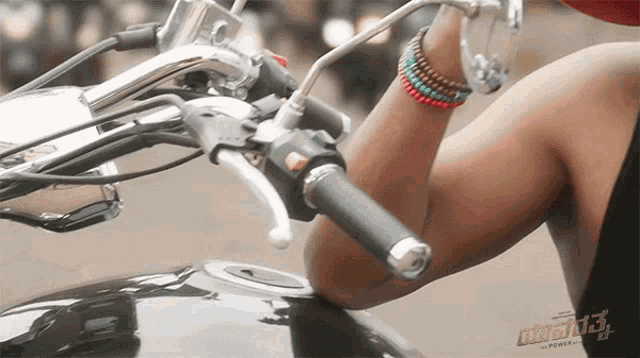 a woman is riding a motorcycle with a sticker on the tank that says power