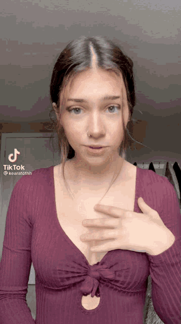 a woman in a purple top has a tiktok sticker on her chest