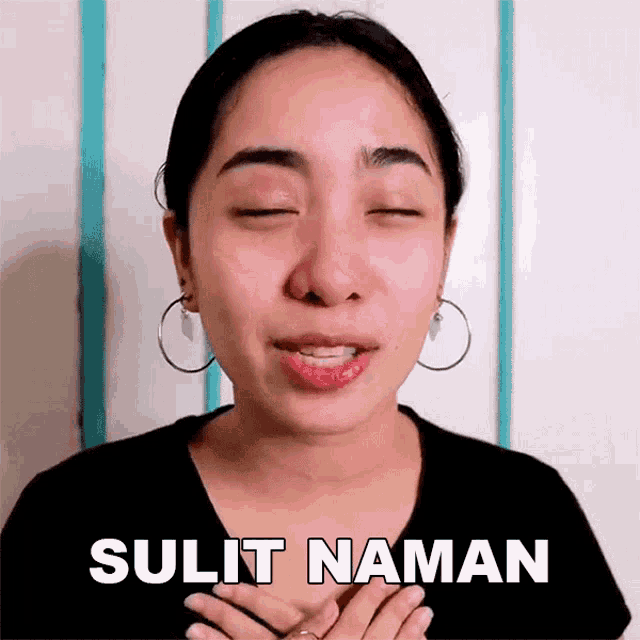 a woman with her eyes closed is wearing hoop earrings and has the word sulit written on her face .