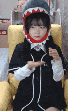 a girl wearing a shark hat and a shirt that says xol on it