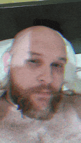 a man with a beard is laying on a bed