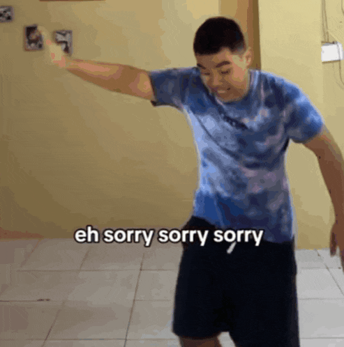 a man in a blue tie dye shirt is dancing with the words eh sorry sorry sorry written below him