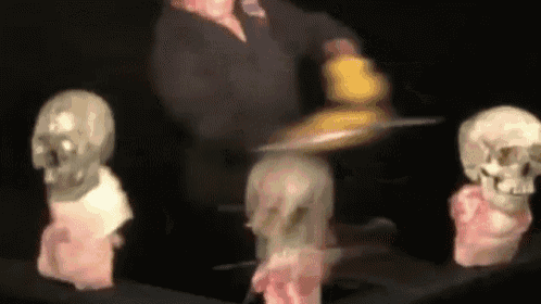 a blurred image of a person holding a tray in front of skulls