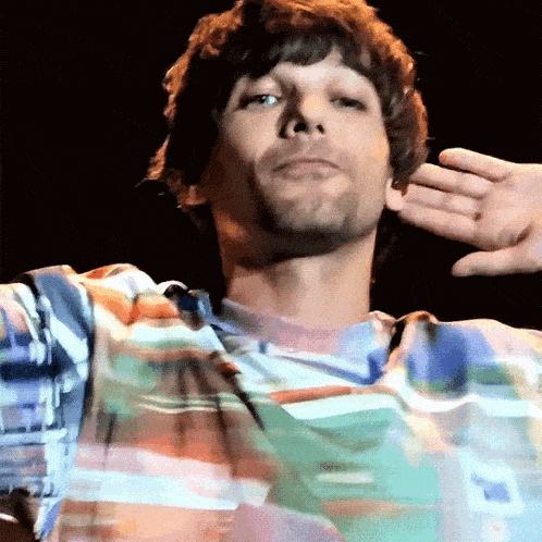 a man in a colorful shirt is making a funny face .