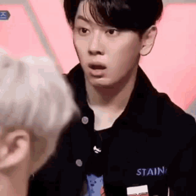 a young man with a surprised look on his face is standing next to another man .
