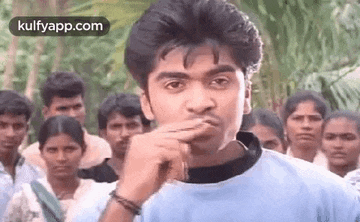 a man is making a funny face in front of a group of people .