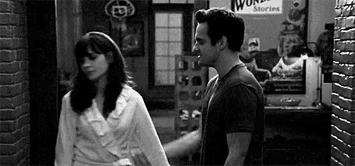 a man and a woman are holding hands in a hallway .