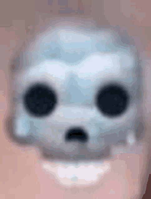 a close up of a skull with black eyes on a pink background .