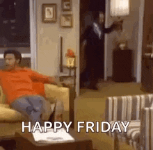a man is sitting on a couch in a living room with the words `` happy friday '' written on it .
