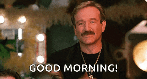 a man with a mustache is smiling and saying good morning .