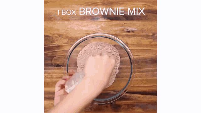 a person is mixing a brownie mix in a glass bowl .