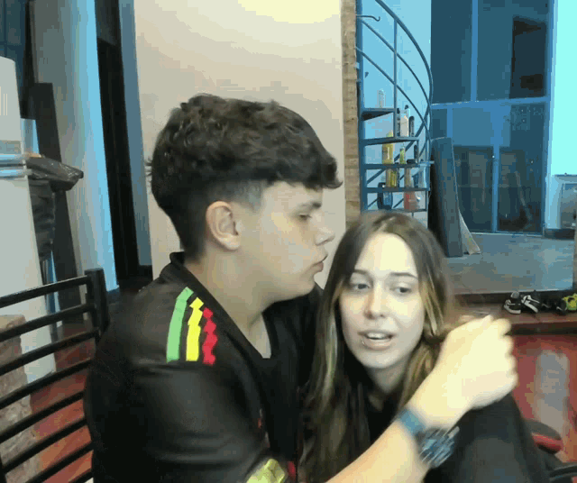 a man and a woman are hugging each other and the man is wearing a shirt that says ' rasta ' on it