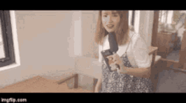 a woman is standing in a room with a microphone in her hand .