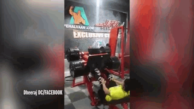 a man is using a machine in a gym to lift dumbbells .