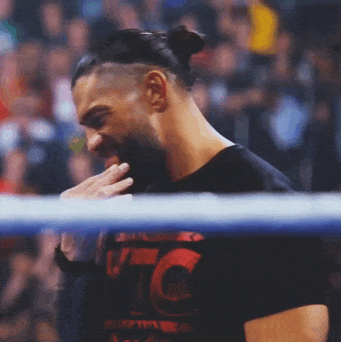 a man in a wrestling ring wearing a shirt that says tc on it