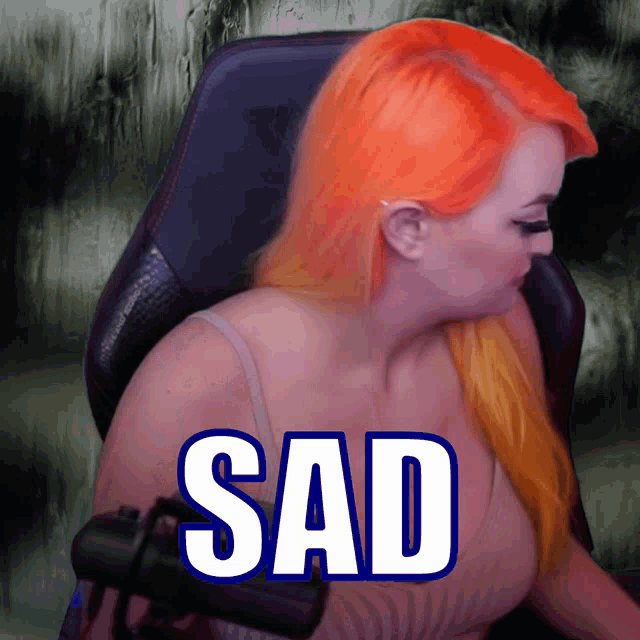 a woman with orange hair is sitting in a chair with the word sad above her head
