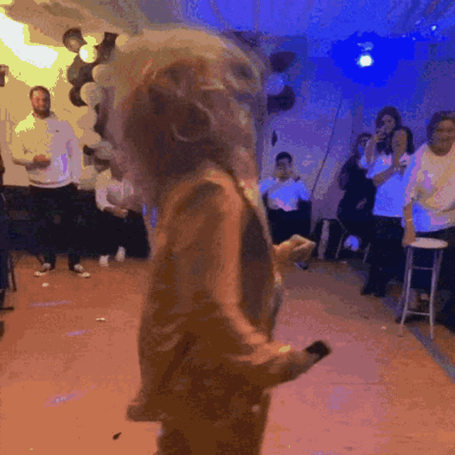 a group of people are dancing in a dark room
