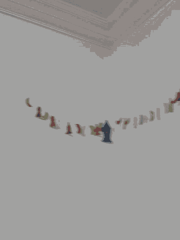 a white wall with a string of colorful letters hanging from it