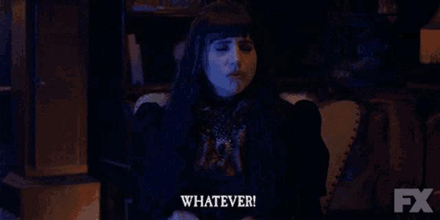 a woman in a dark room says whatever