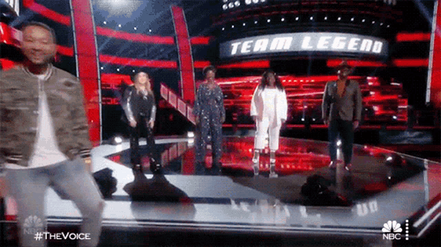 a man is dancing on a stage in front of a team legend sign