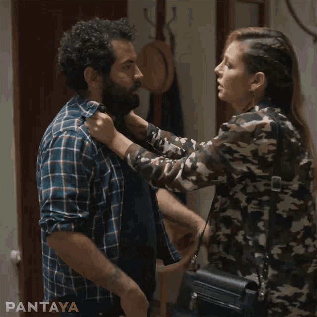 a man in a plaid shirt is being punched by a woman in a camo top