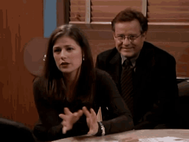 a man and a woman are sitting at a table and talking