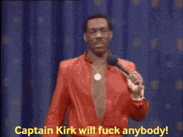 a man in a red jacket stands in front of a microphone and says captain kirk will fuck anybody