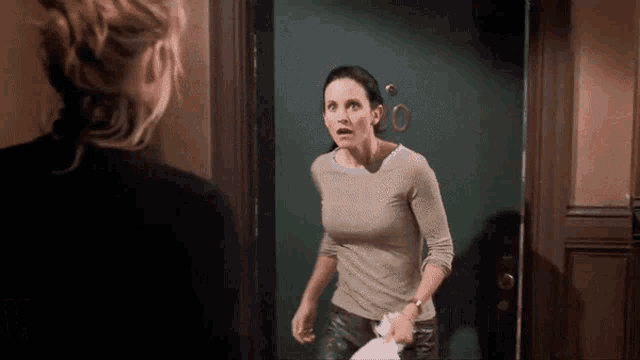 a woman is standing in front of a door with the number 20 on it