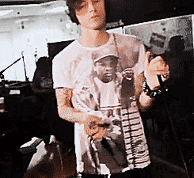 a man wearing a t-shirt with a picture of a man holding a microphone