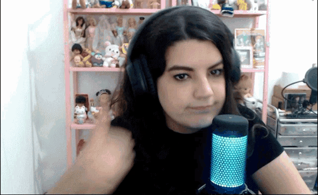 a girl wearing headphones and a microphone looks at the camera