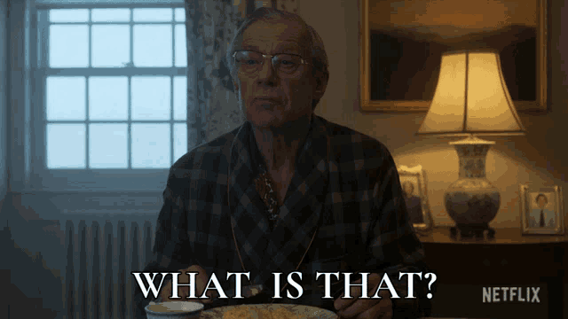 a man is sitting at a table with a plate of food and the words what is that on the bottom