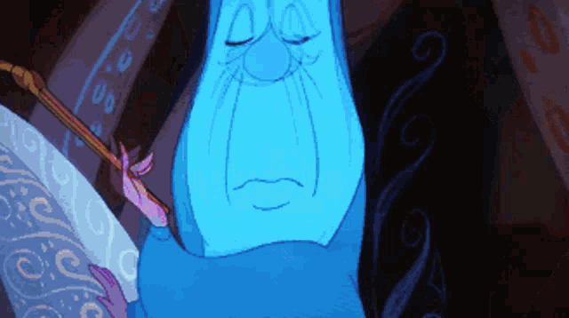 a blue cartoon character with a sad look on his face is holding a wand