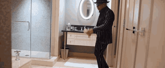 a man in a striped suit is standing in a bathroom
