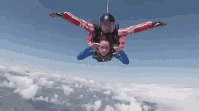 a man and a woman are jumping out of a plane .