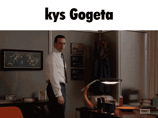 a man in a white shirt and tie stands in front of a desk with the words kys gogeta written above him
