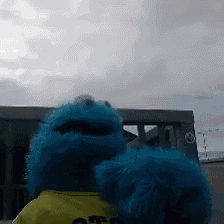 a blue stuffed animal is wearing a yellow shirt that says ' off ' on it