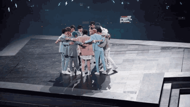 a group of people standing in a circle on a stage with a sign that says ' a ' on it