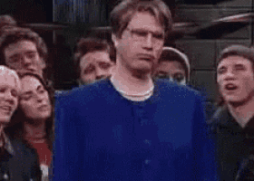 a man in a blue shirt is standing in a bathroom .
