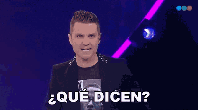 a man wearing a black jacket and a t-shirt with the word x on it