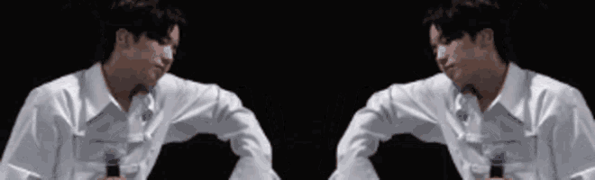 a man in a white shirt is shaking hands with another man