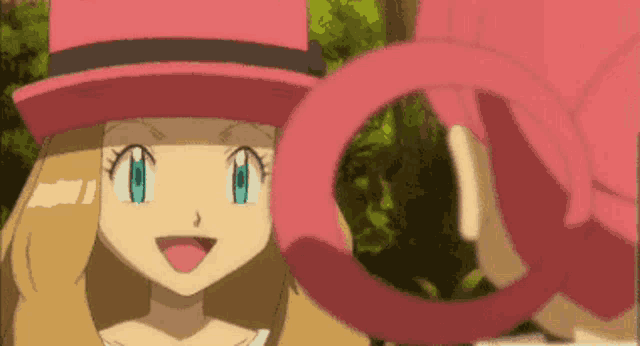 a girl in a pink hat is holding a pink object in her hand