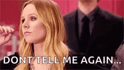 a woman is sitting in front of a man in a suit and tie and says `` don t tell me again ... '' .