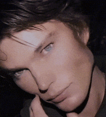 a close up of a man 's face with blue eyes looking at the camera