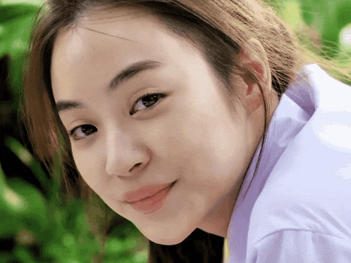 a close up of a woman 's face with a white shirt on